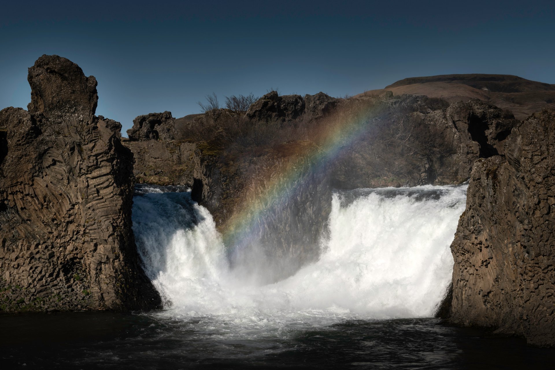 Twin cascades of Hjálparfoss surrounded by columnar basalt