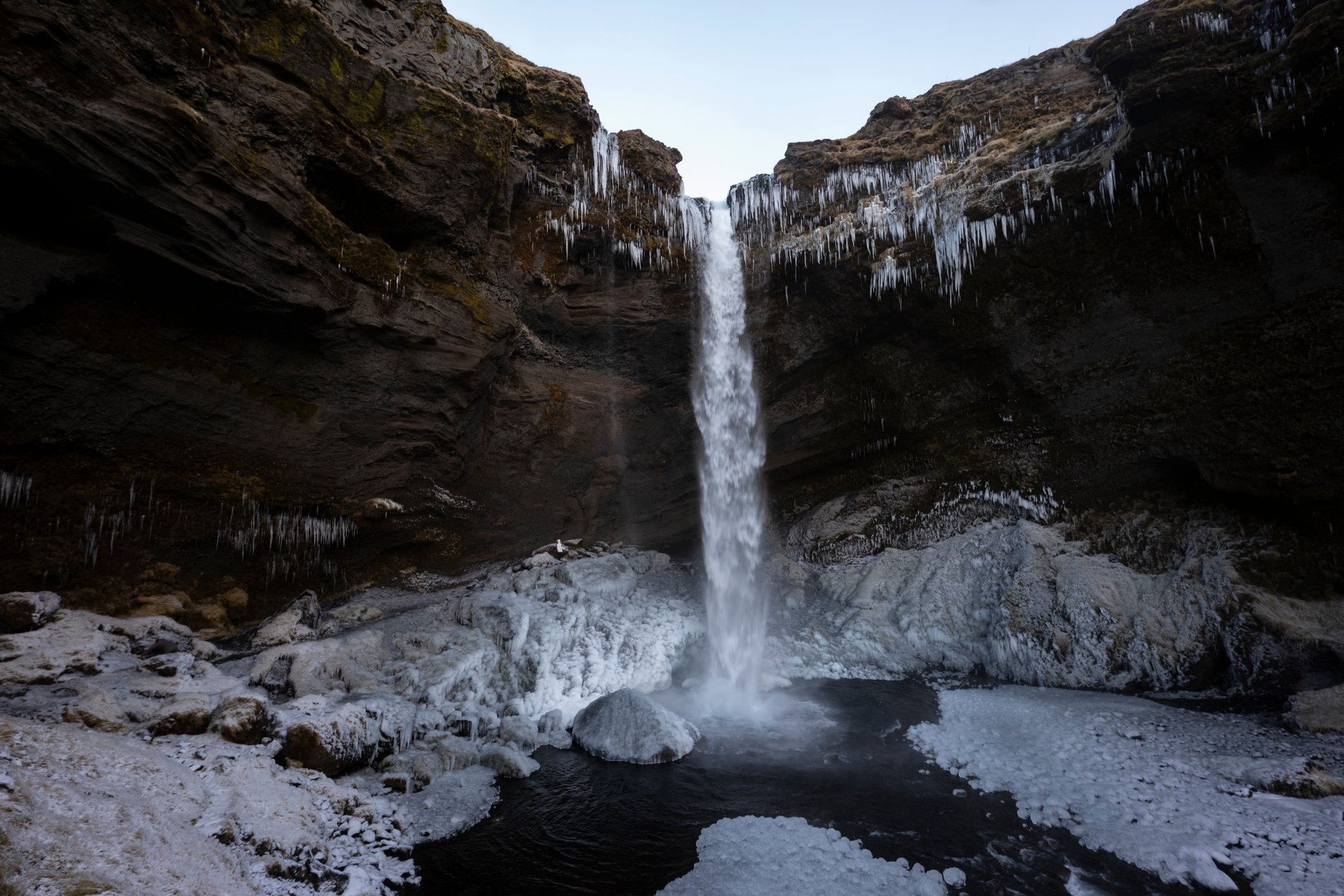 Walking behind the curtain of water at Kvernufoss