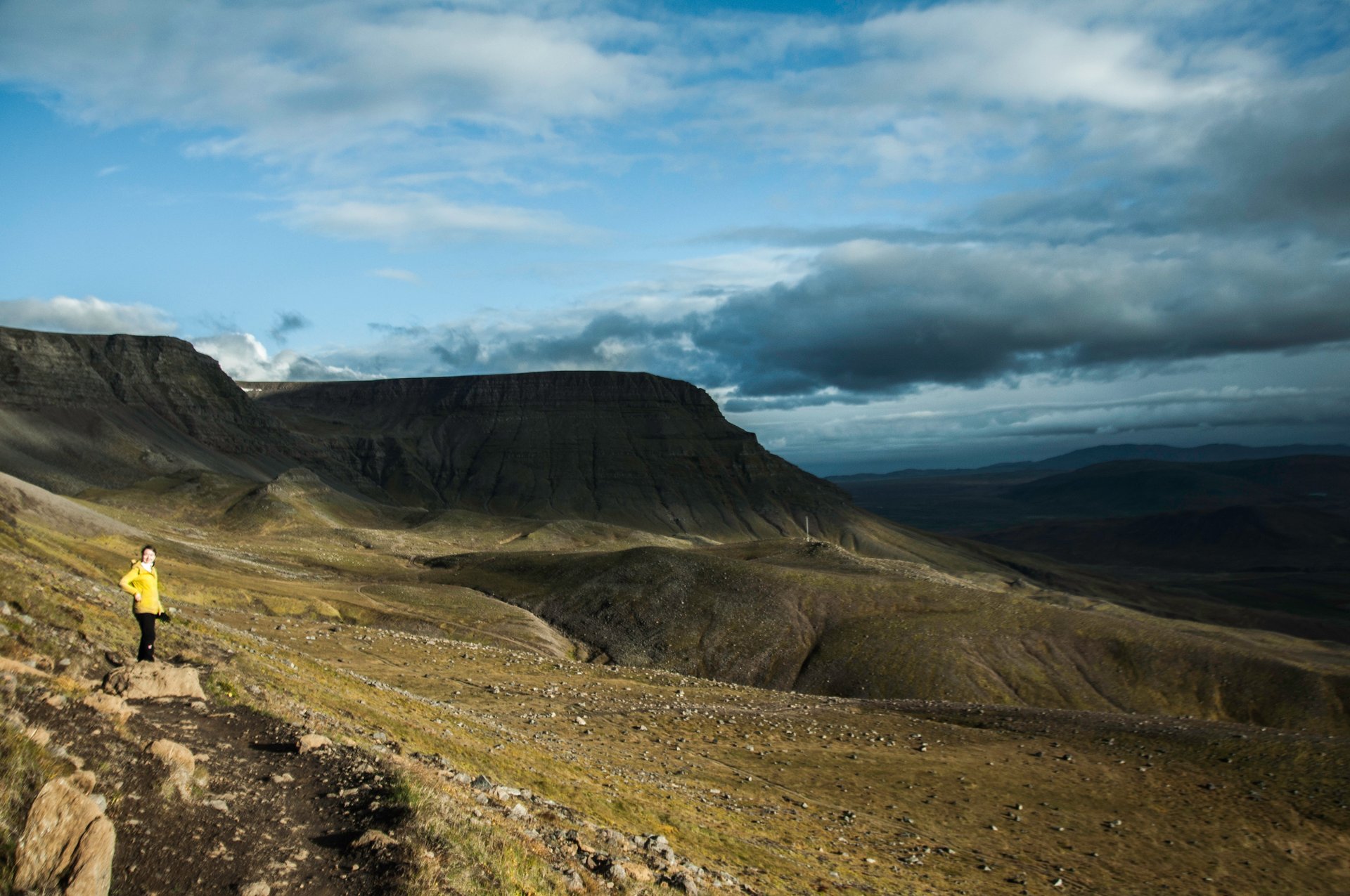 Hikers ascending the rocky upper section of Mount Esja with panoramic views