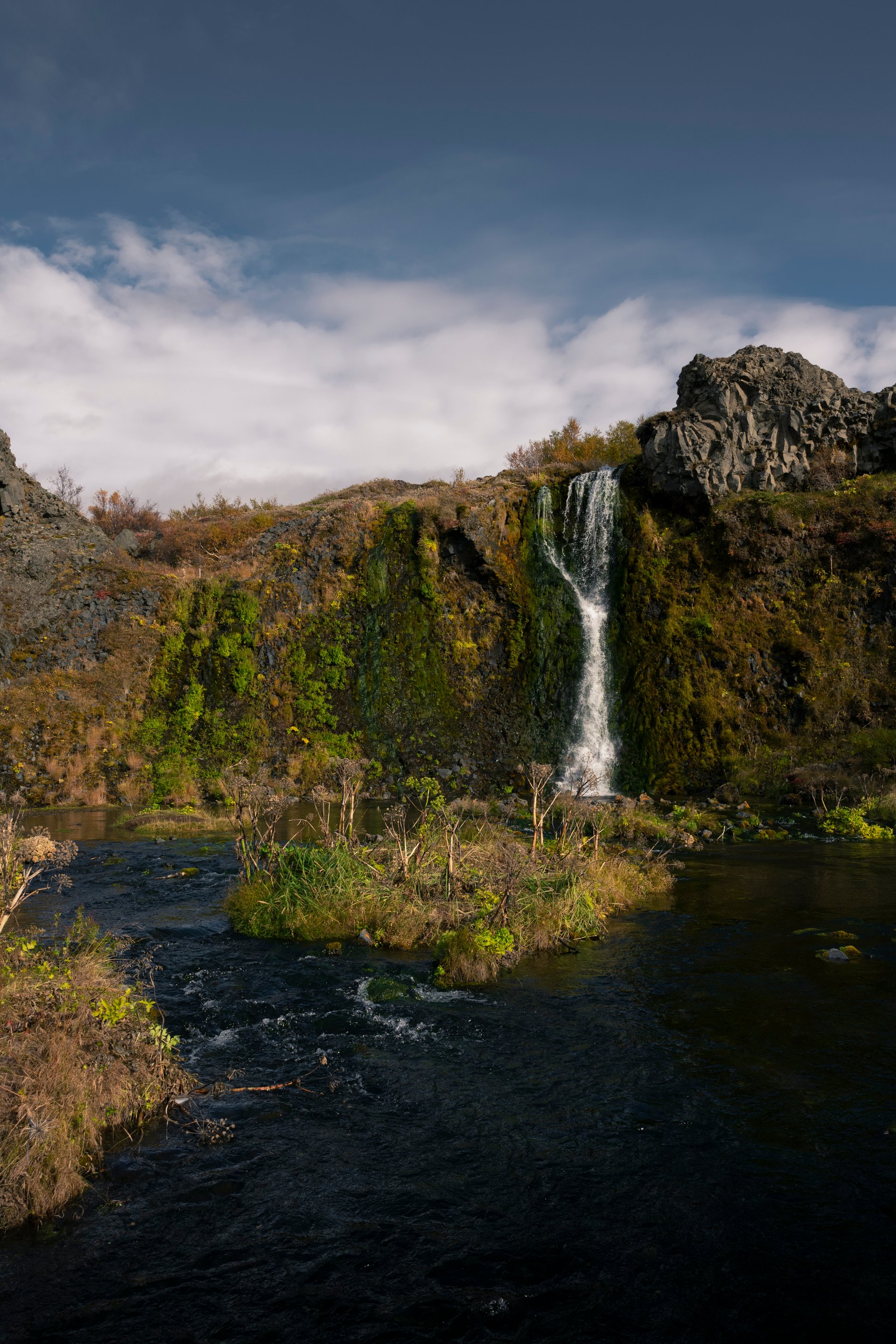 Gjáin valley oasis with cascading waterfalls and lush green moss