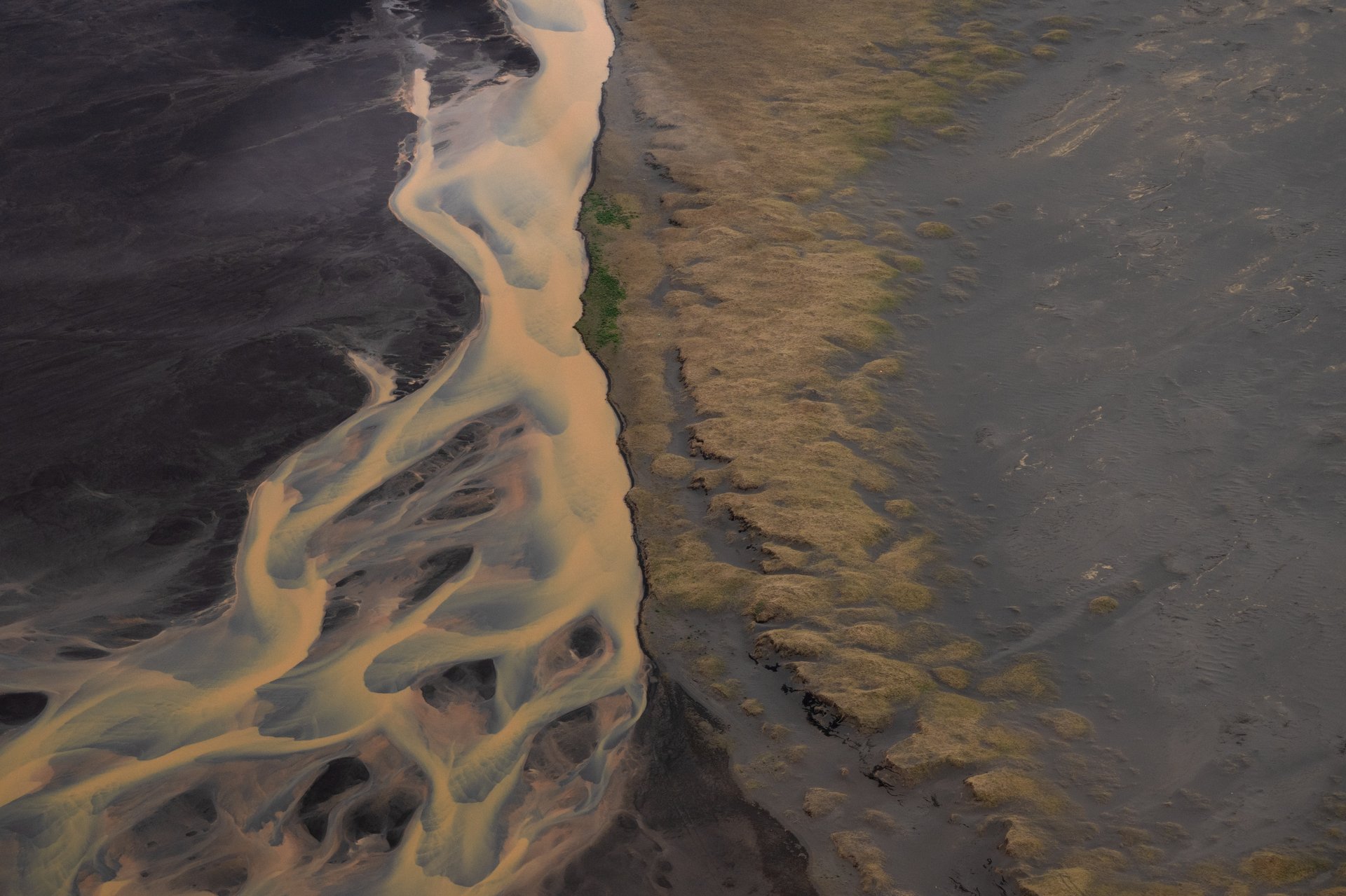 Black lava fields contrast with green moss aerial view
