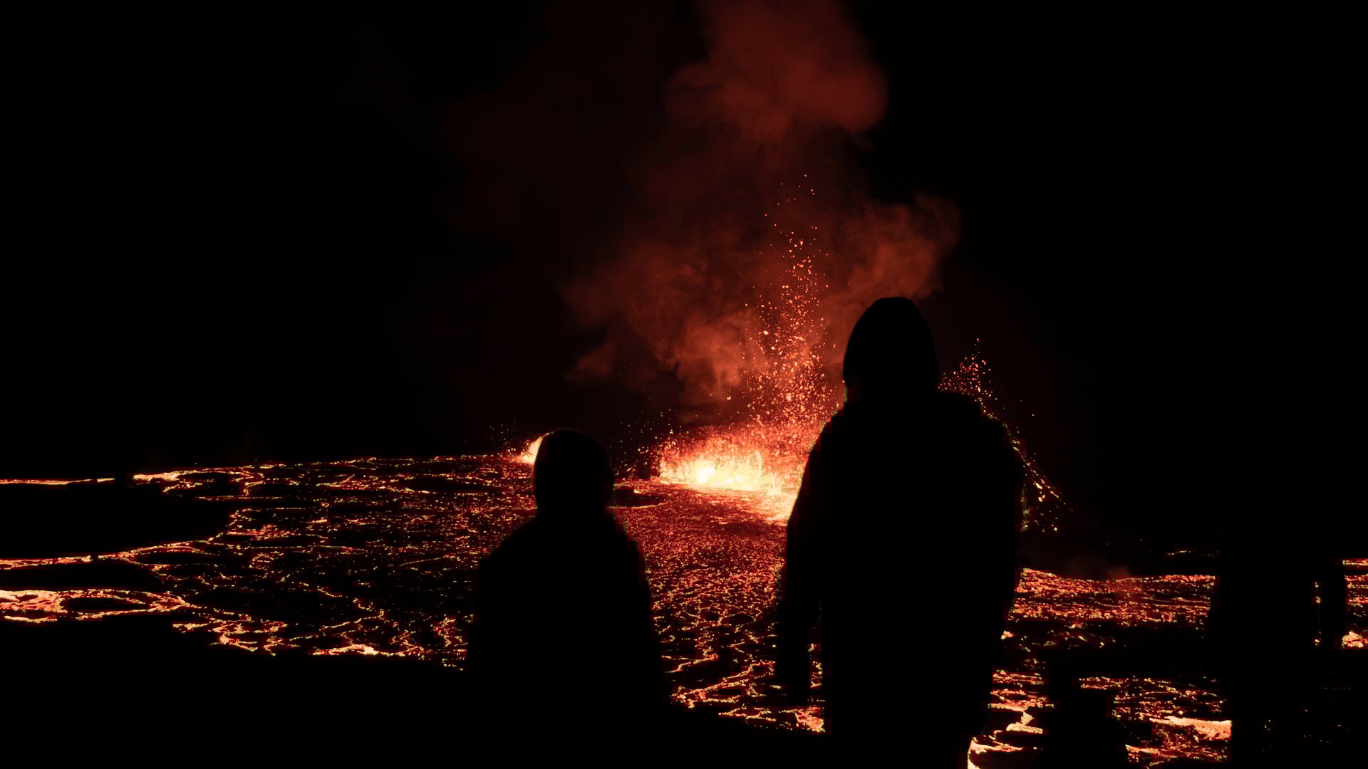 Romantic silhouette of couple watching volcanic eruption together
