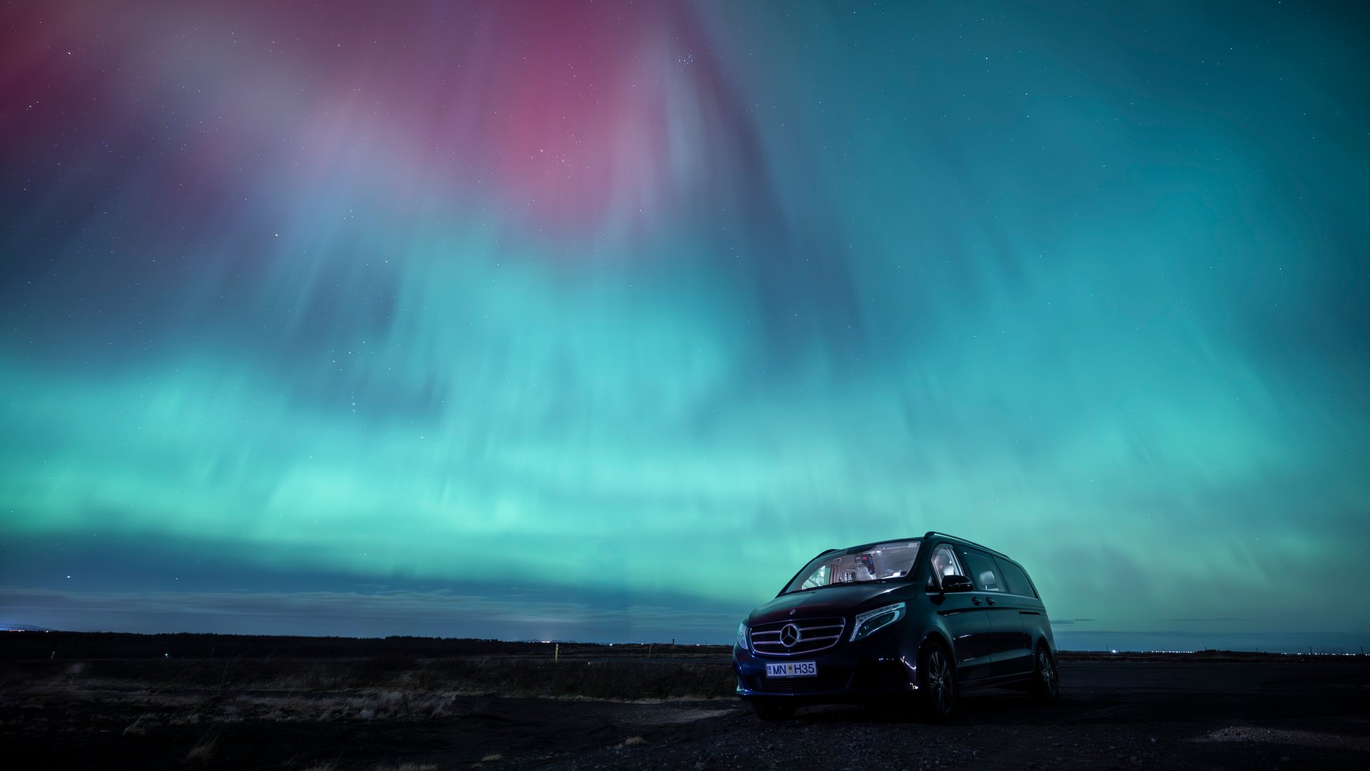 Luxury vehicle under spectacular northern lights