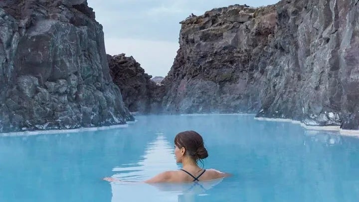 Woman bathing in the milky blue waters of the Blue Lagoon Retreat