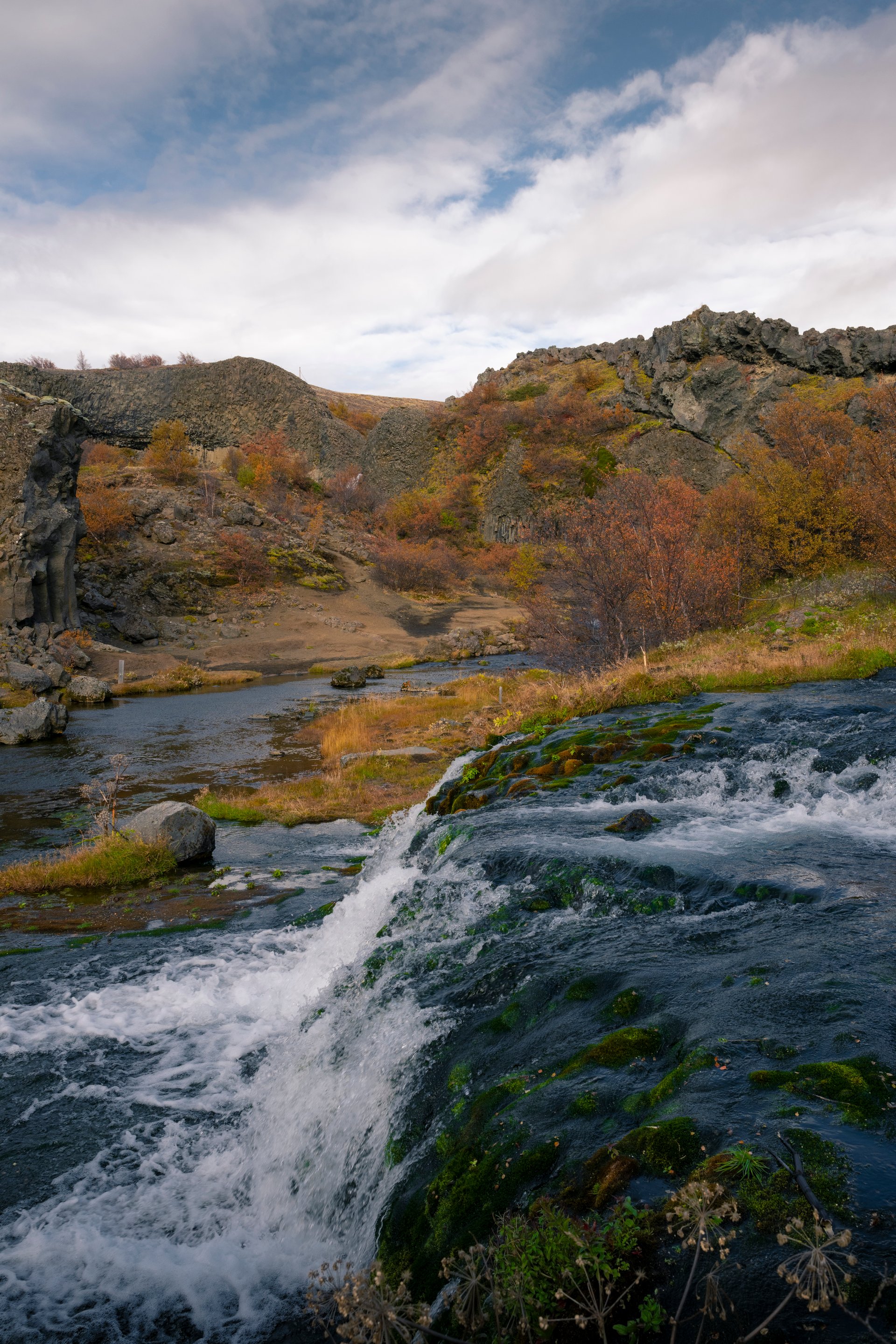 Gjáin valley with small waterfalls and lush green vegetation