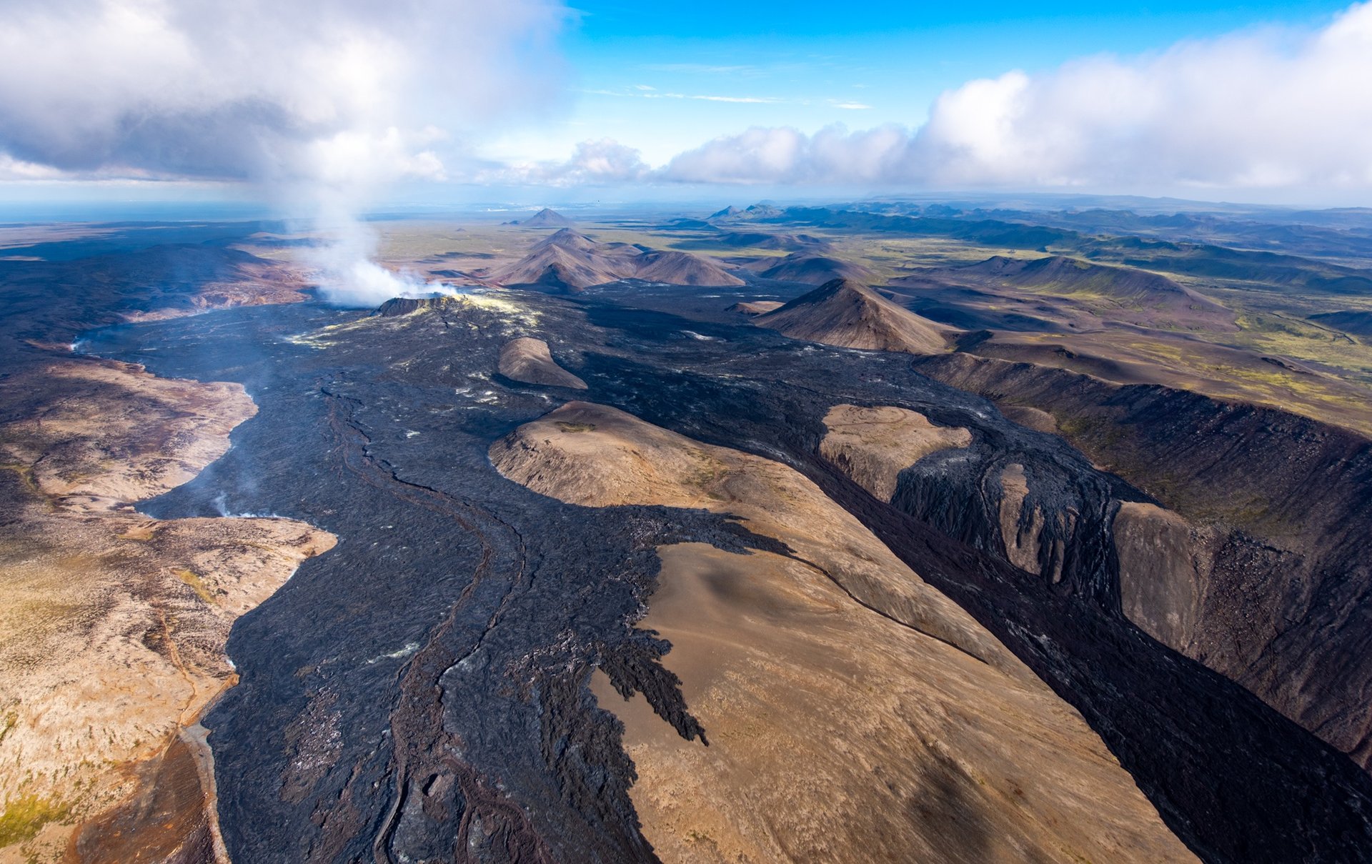 Aerial view of volcanic lava flows and eruption landscapes from helicopter