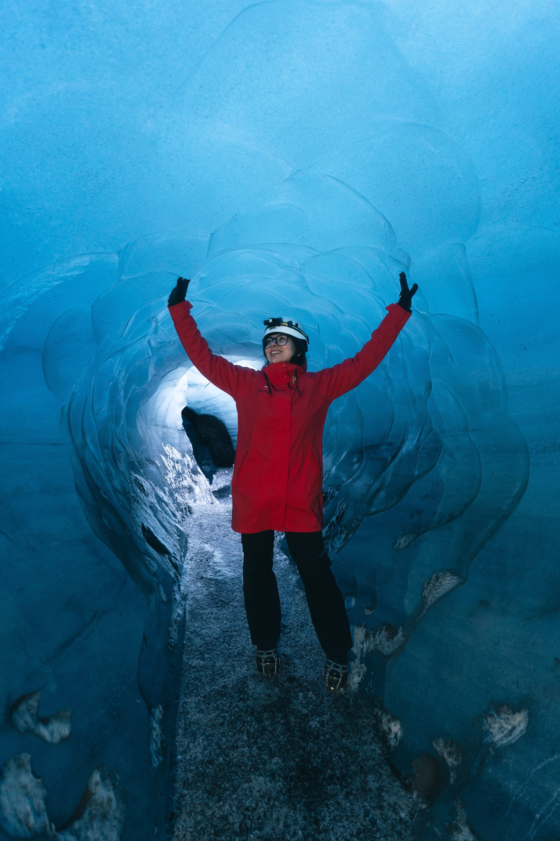 Explorer with headlamp in Katla ice cave passage