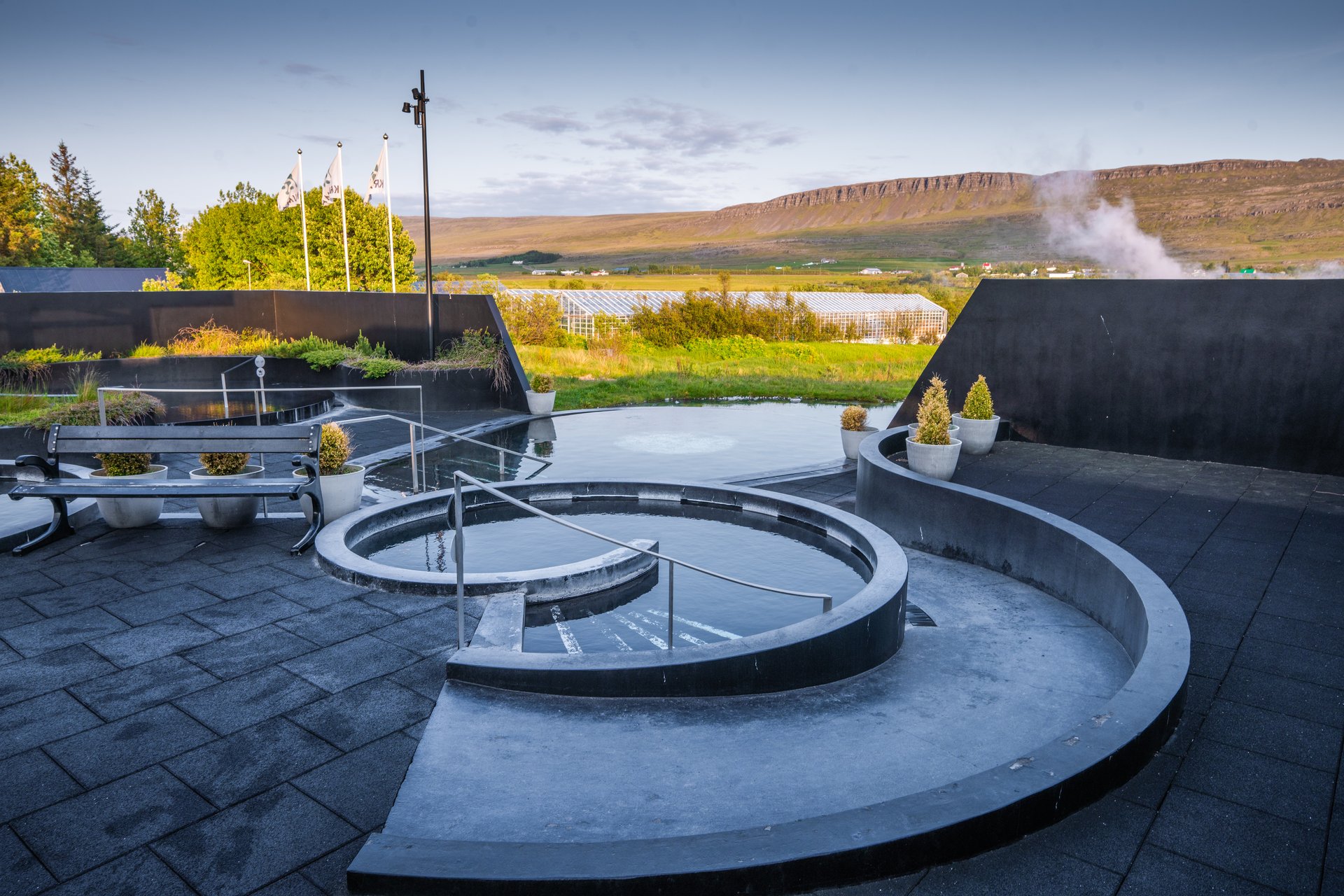 Steaming geothermal pools with mountain backdrop at Krauma Spa West Iceland