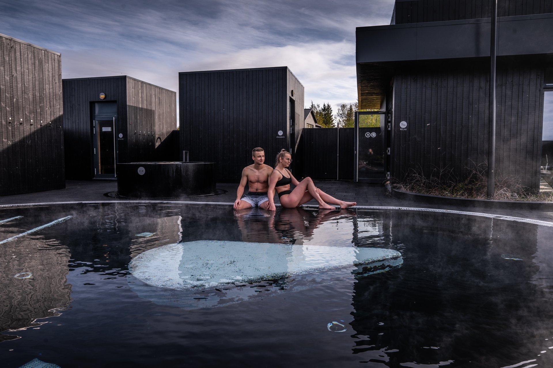 Steaming geothermal baths surrounded by scenic West Iceland landscape at Krauma