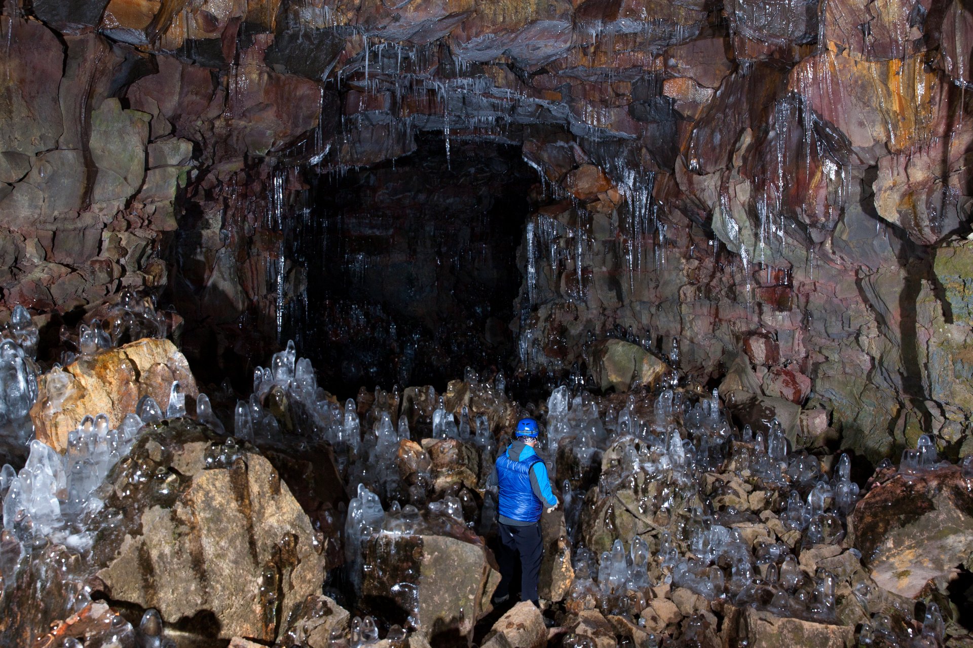 Deep inside Raufarhólshellir lava tunnel exploring volcanic formations