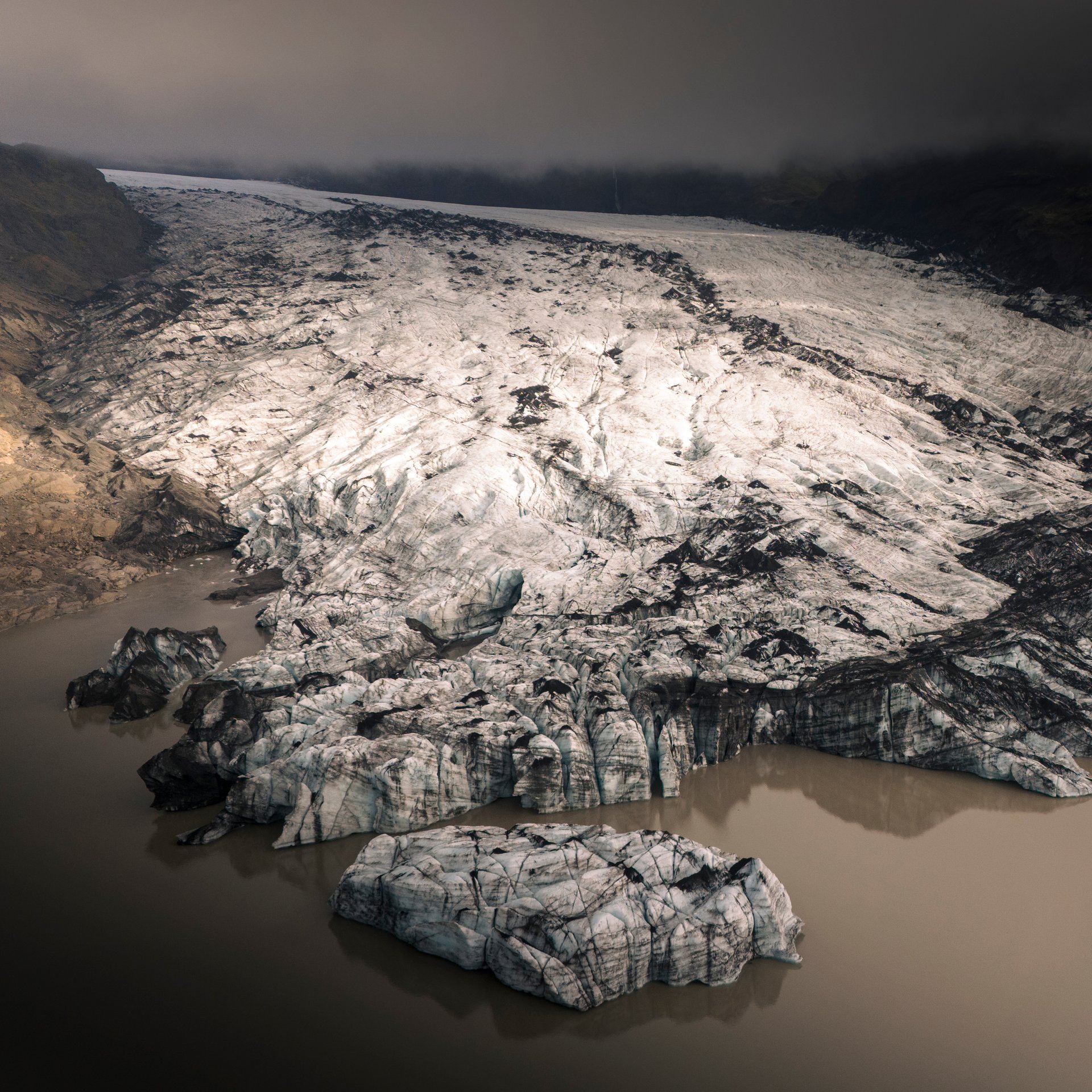 Professional glacier guide demonstrating ice climbing techniques