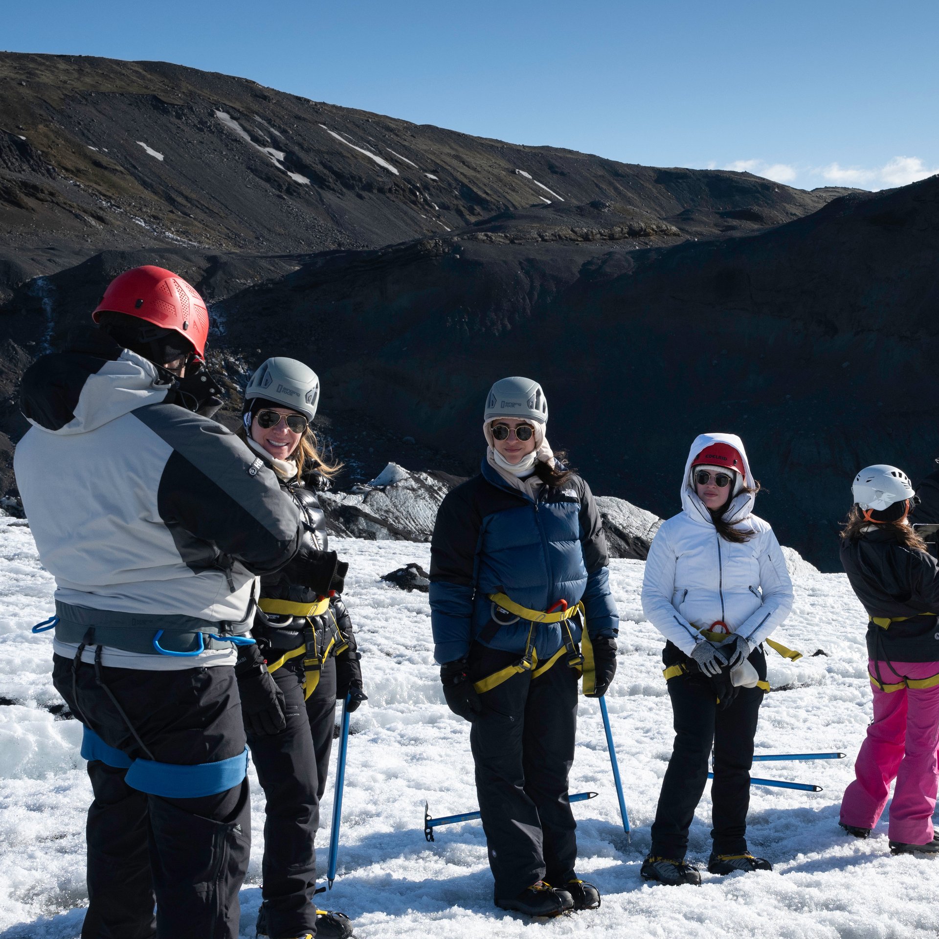 Icy landscape with hikers using crampons and helmets