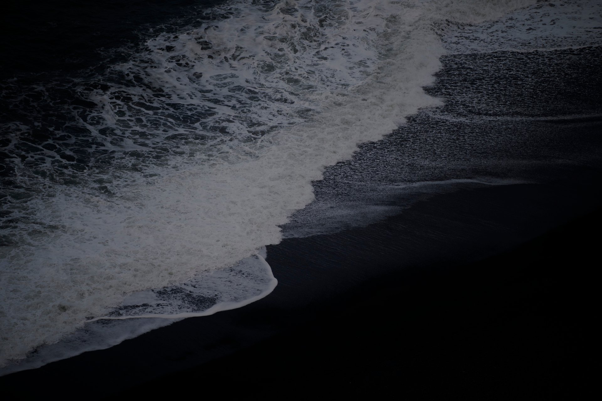 Dramatic Reynisfjara black sand beach with basalt sea stacks and powerful Atlantic waves
