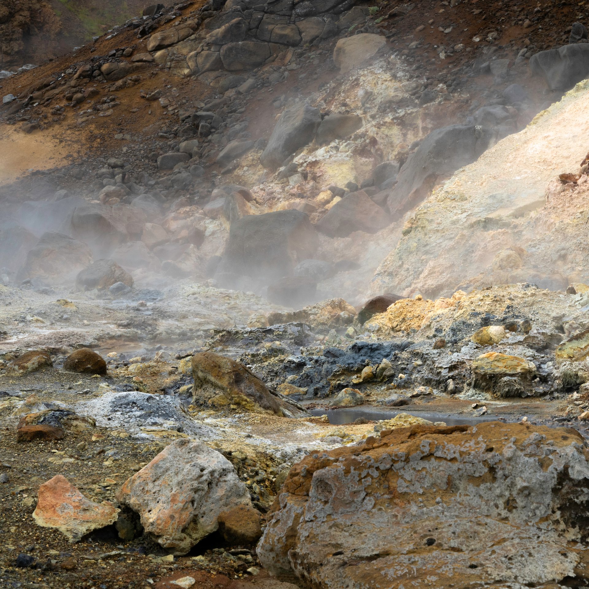 Colorful mineral deposits and steaming mud pots at Seltún geothermal area on Reykjanes