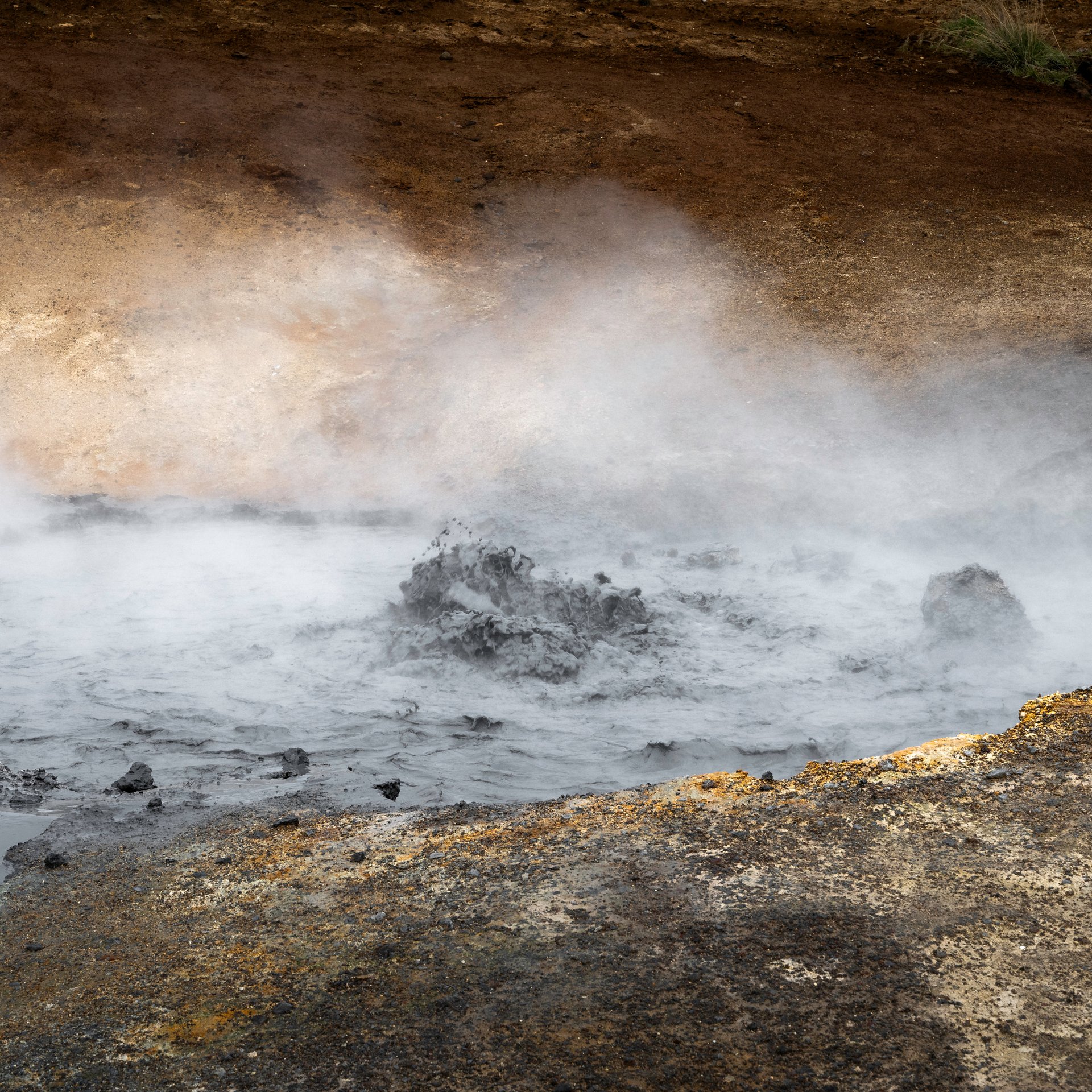 Colorful mineral deposits and steaming mud pots at Seltún geothermal area