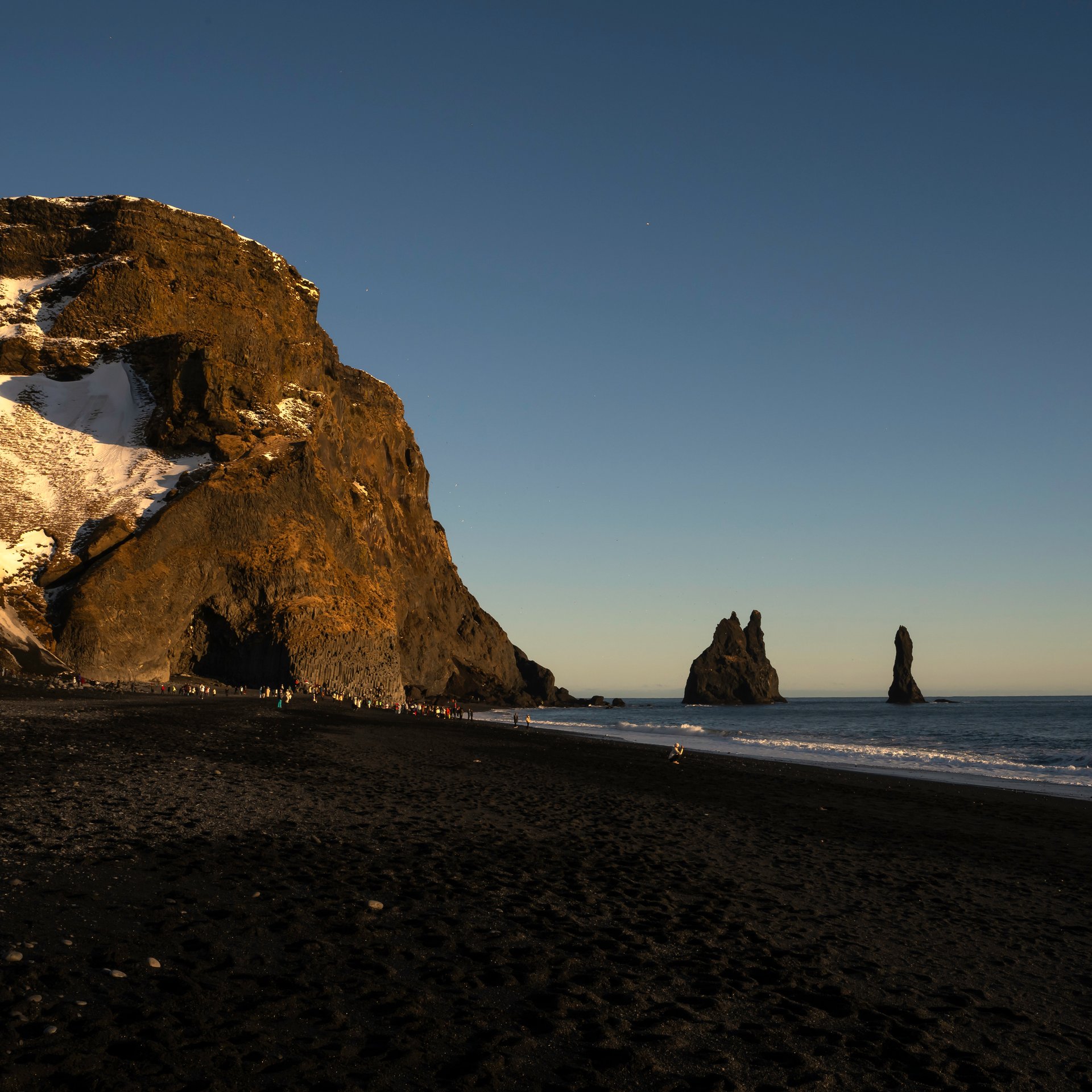 Reynisfjara black sand beach with basalt sea stacks and dramatic cliffs